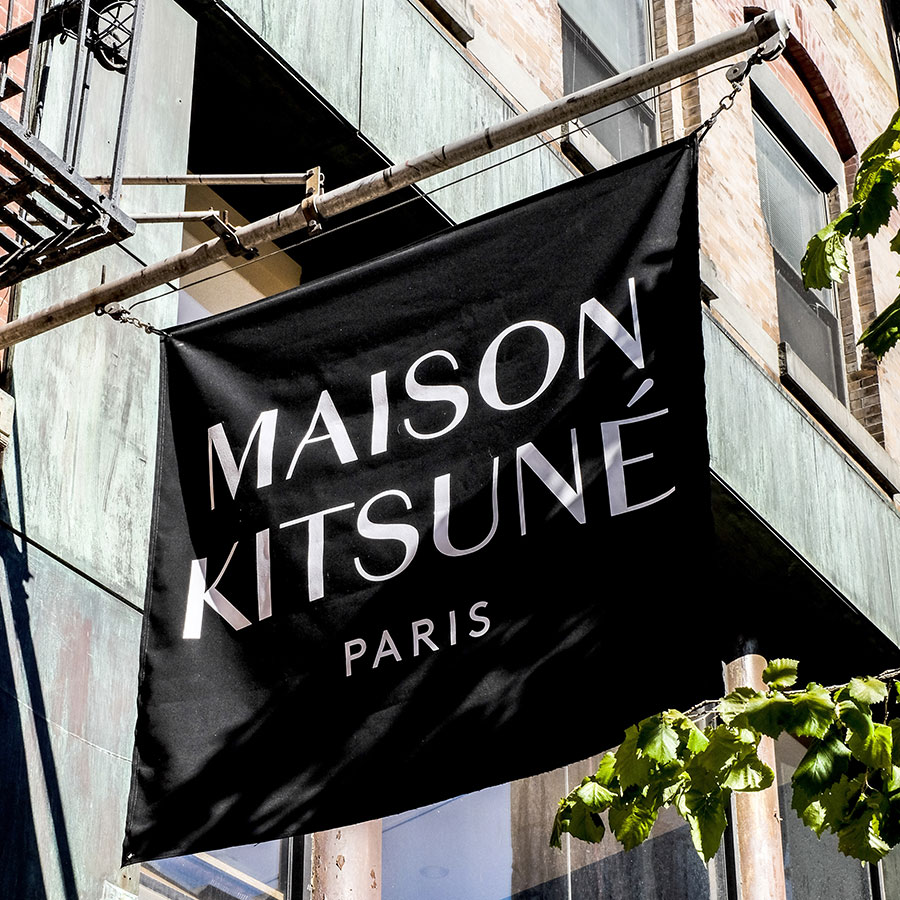 A flag that reads Maison Kitsune outside of the store