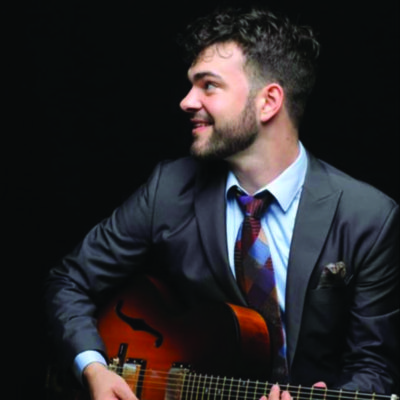 a headshot of guitarist Andrew Latona for his live performance at the Roxy bar
