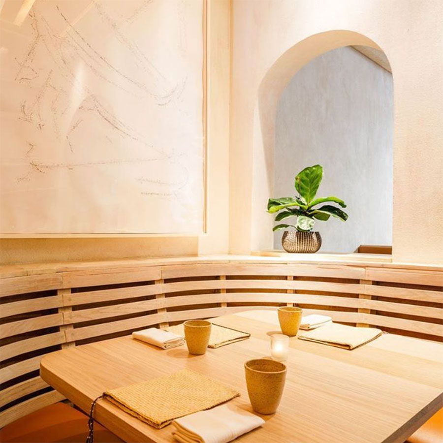 Beige booth and table with an arched window in the background