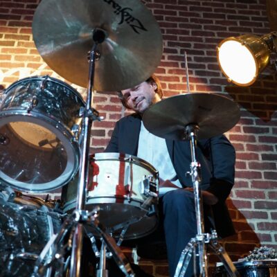 Bill Dobrow sitting behind a drum set and cymbals