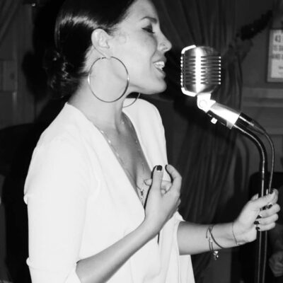 Danielle Illario singing into a big microphone
