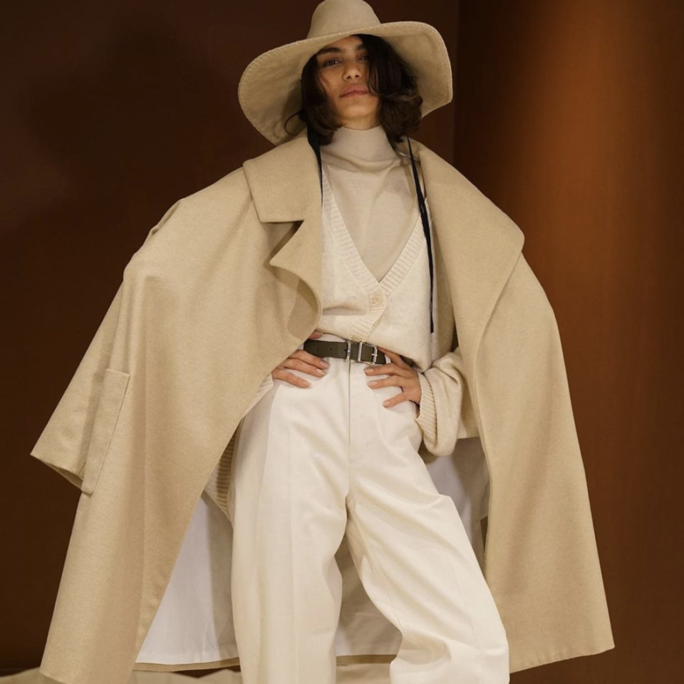 Model wearing white suite and beige coat